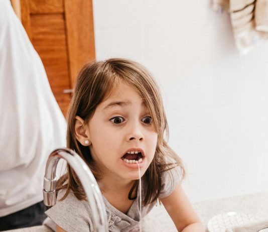 At What Age Should You Teach Kids to Floss? child flossing teeth